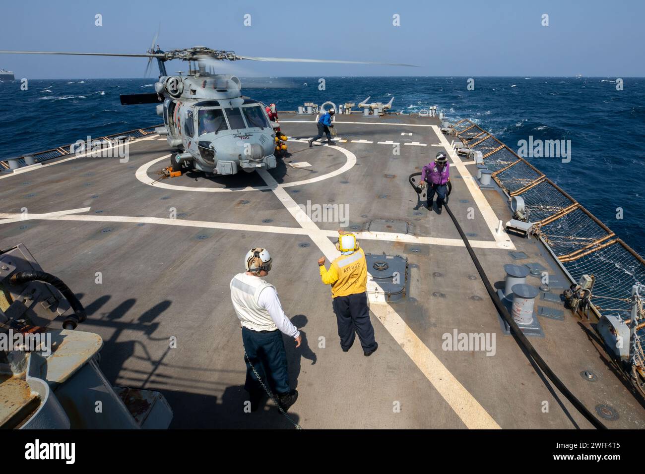 I marinai della Marina degli Stati Uniti assegnati al cacciatorpediniere a missili guidati USS Laboon (DDG 58) finiscono di alimentare un elicottero MH-60R attaccato alla "Swamp Foxes" dell'Helicopter Maritime Strike Squadron (HSM) 74 sul ponte di volo nel Mar Rosso, 9 gennaio 2024. Laboon è schierato nella 5th Fleet area of Operations degli Stati Uniti per contribuire a garantire la sicurezza marittima nella regione del Medio Oriente. (Foto della Marina degli Stati Uniti di Mass Communication Specialist di terza classe Alice Husted) Foto Stock