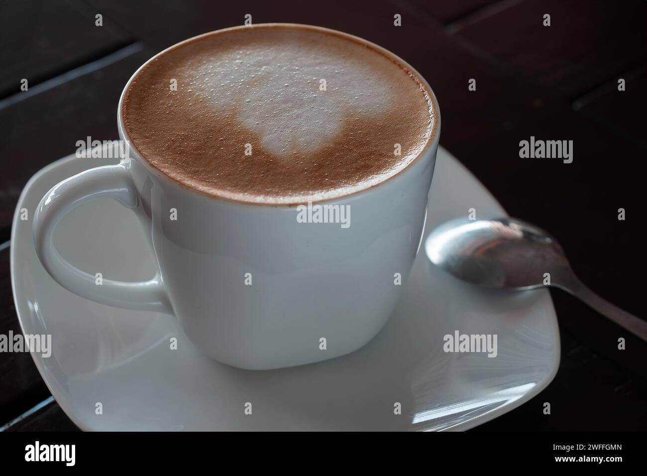 una tazza di cappuccino caldo con crema a forma di fiore Foto Stock