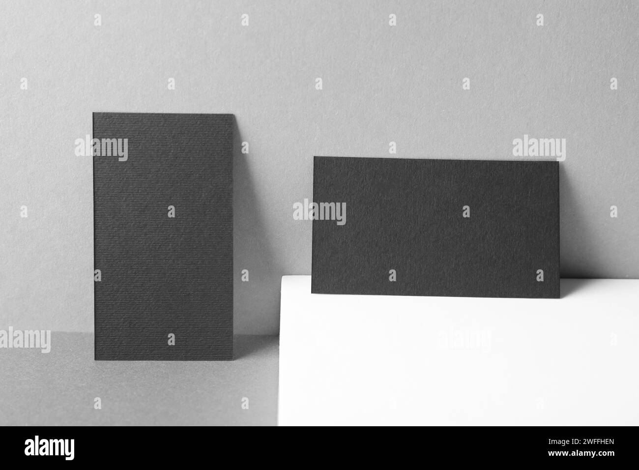 Biglietti da visita neri vuoti su sfondo grigio. Modello per il design Foto Stock