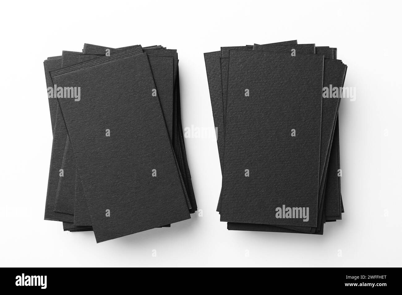 Biglietti da visita neri vuoti su sfondo bianco, vista dall'alto. Mockup per il design Foto Stock