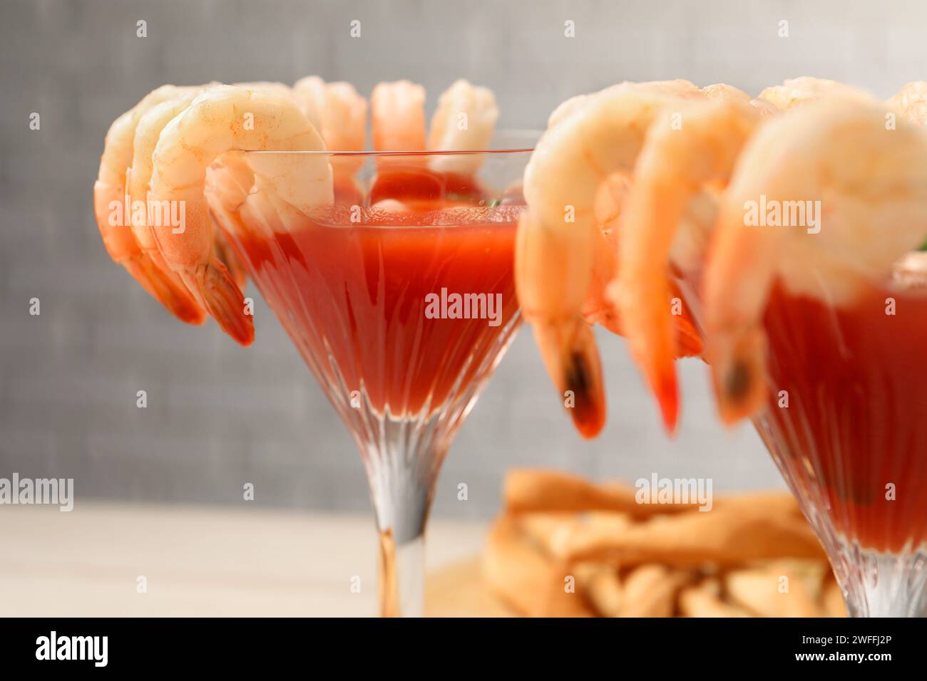 Gustoso cocktail di gamberi con salsa nei bicchieri sul tavolo, primo piano Foto Stock