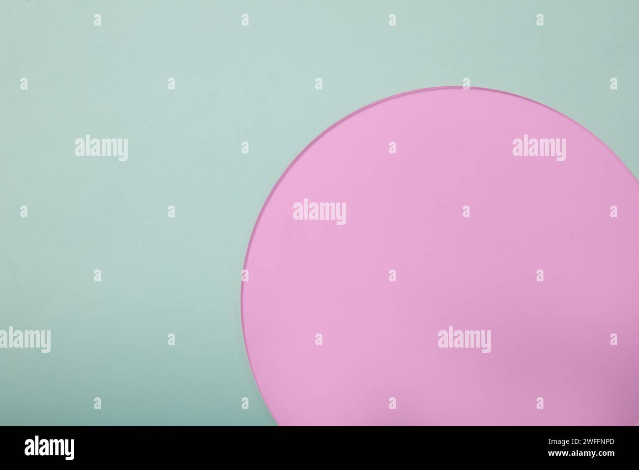 Scenografia minimalista di uno sfondo azzurro con un foglio acrilico rosa a forma rotonda. Spazio di copia sul lato sinistro. Promozione prodotto con vacan Foto Stock