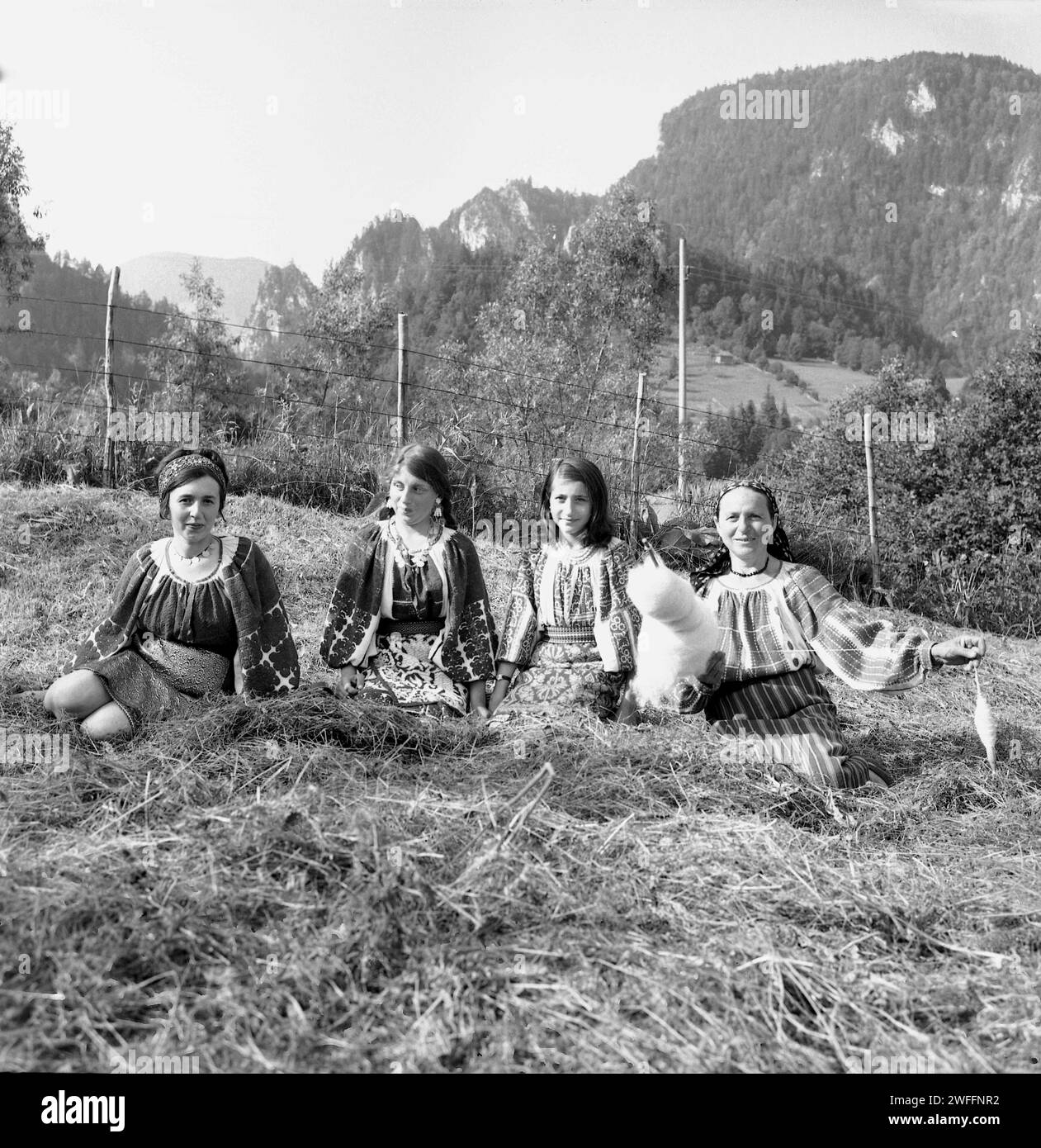 Contea di Vrancea, Romania, circa 1978. Donne che indossano i loro costumi tradizionali. Donna che usa una vecchia tecnica tradizionale e strumenti per filare la lana. Foto Stock