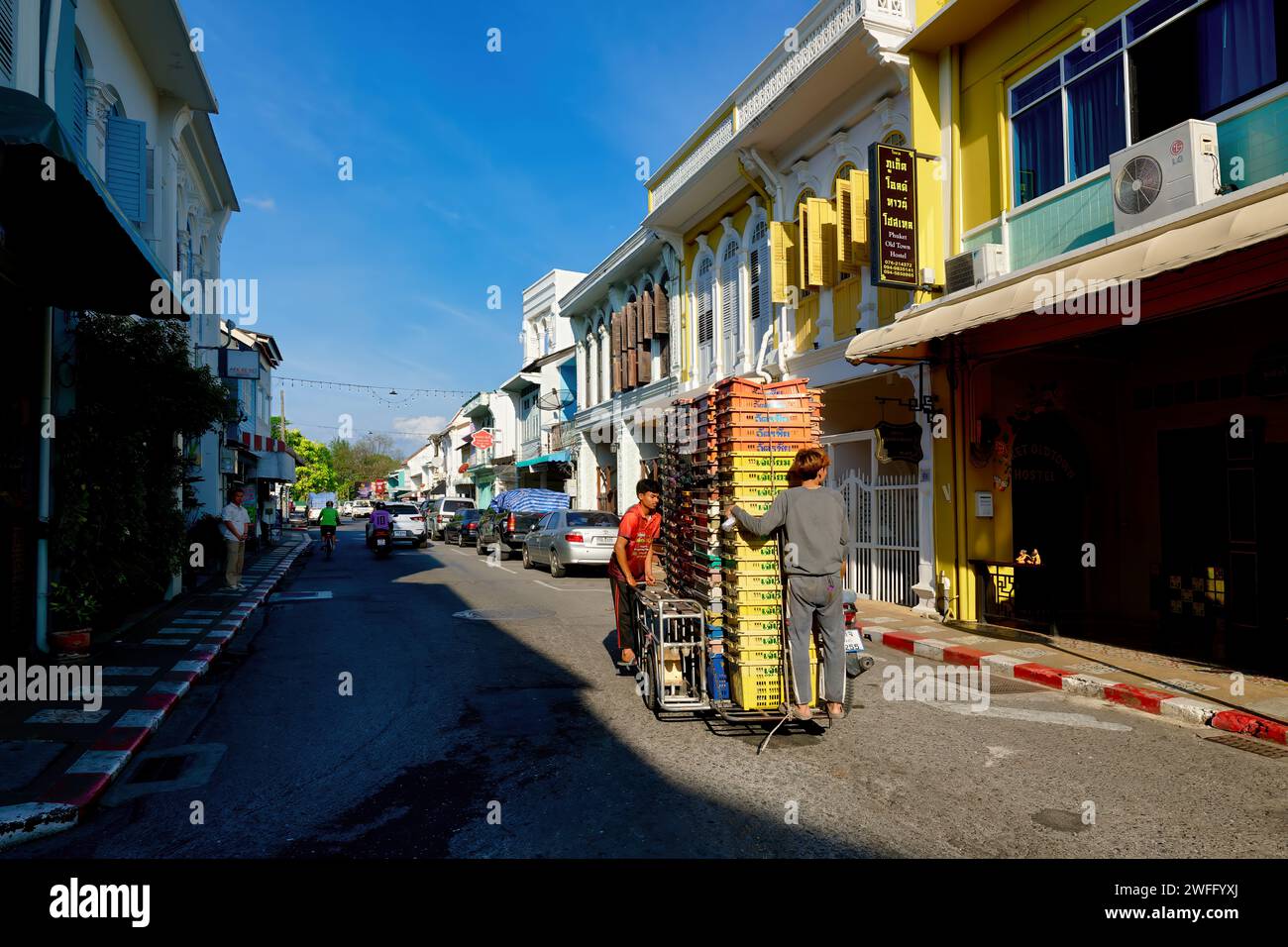 Le colorate botteghe in stile sino-portoghese nella città vecchia sono Phuket Town, Thailandia, una motocicletta con sidecar impilato in alto con casse che passano Foto Stock