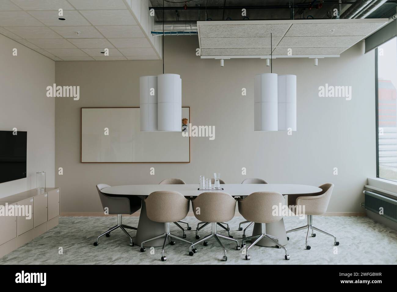 Tavolo da conferenza vuoto con sedie e lampada a sospensione nella sala riunioni Foto Stock