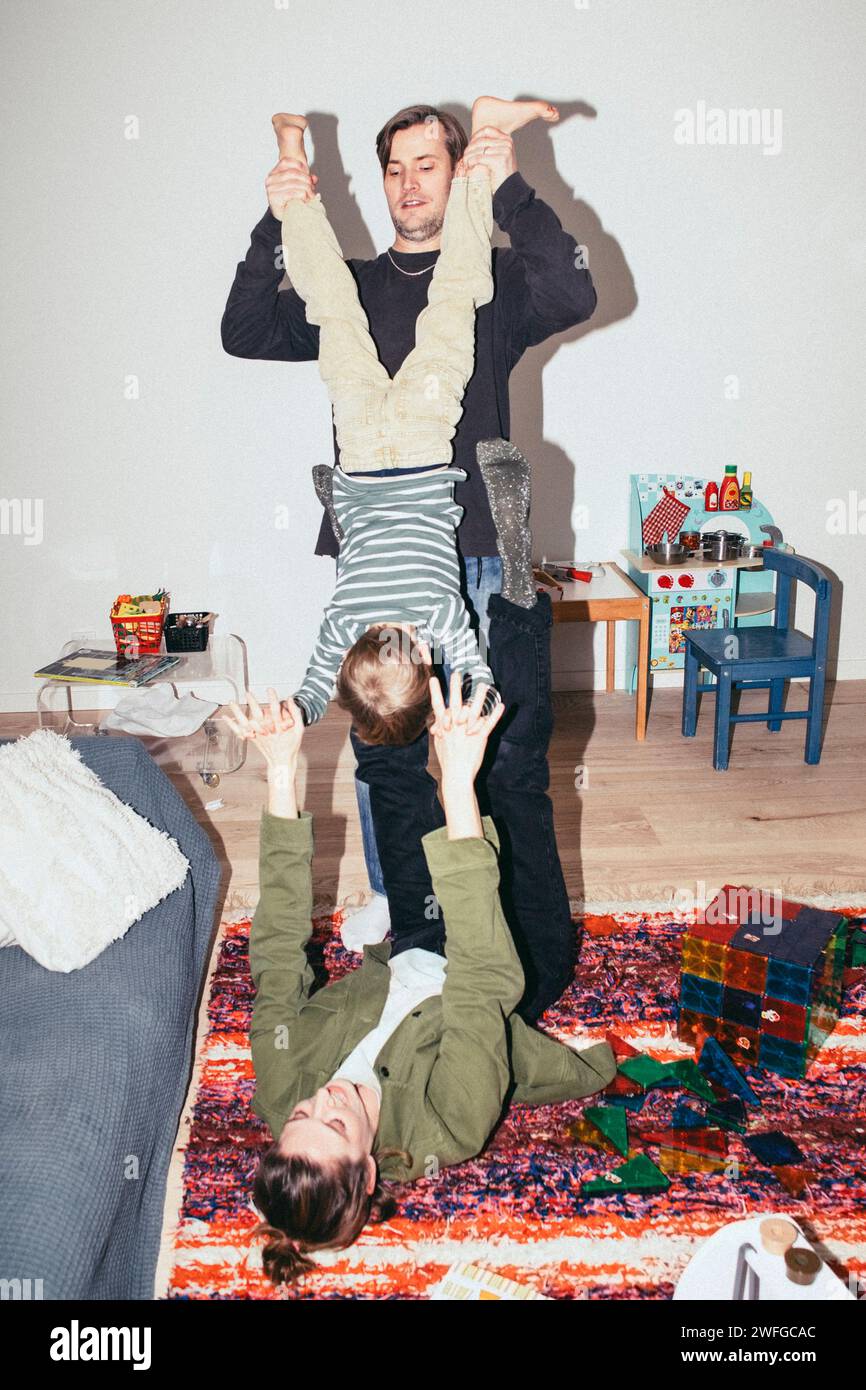 I genitori giocosi si divertono con il figlio a casa Foto Stock