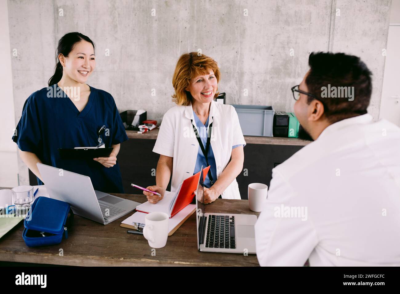 Sorridente team medico multirazziale discutendo in ospedale Foto Stock
