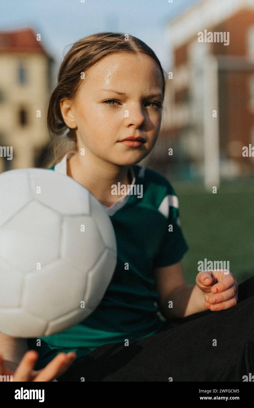 Ritratto di atleta con palla da calcio al campo sportivo Foto Stock