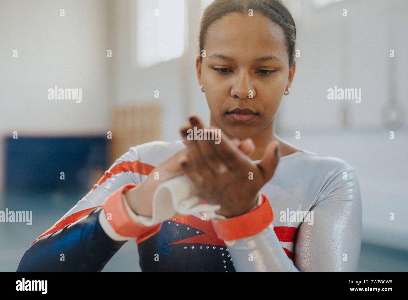 Ragazza adolescente che applica polvere di gesso sulle mani in palestra Foto Stock