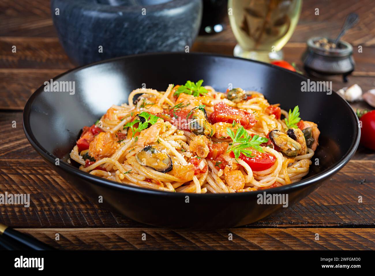 Pasta di pesce con vongole, salmone e pomodori. Spaghetti con cocktail di pesce Foto Stock