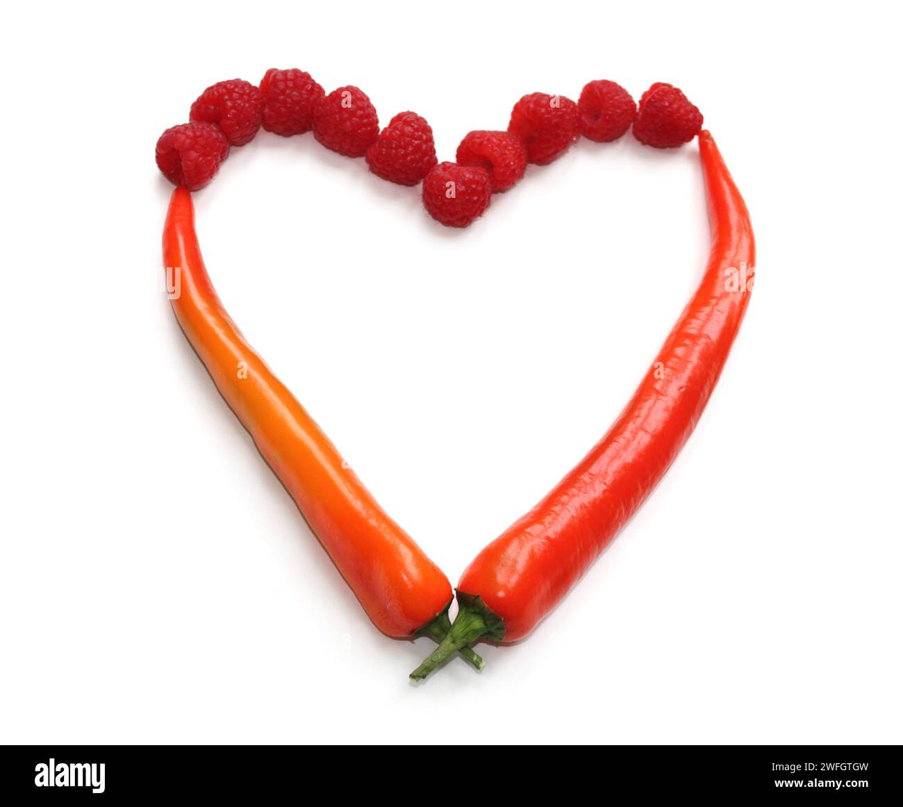 segno del cuore realizzato con peperoncino rosso arancio e lampone, cuore fatto di peperoncini, peperoni, lamponi per decorare le carte del menu, volantino, brochure Foto Stock