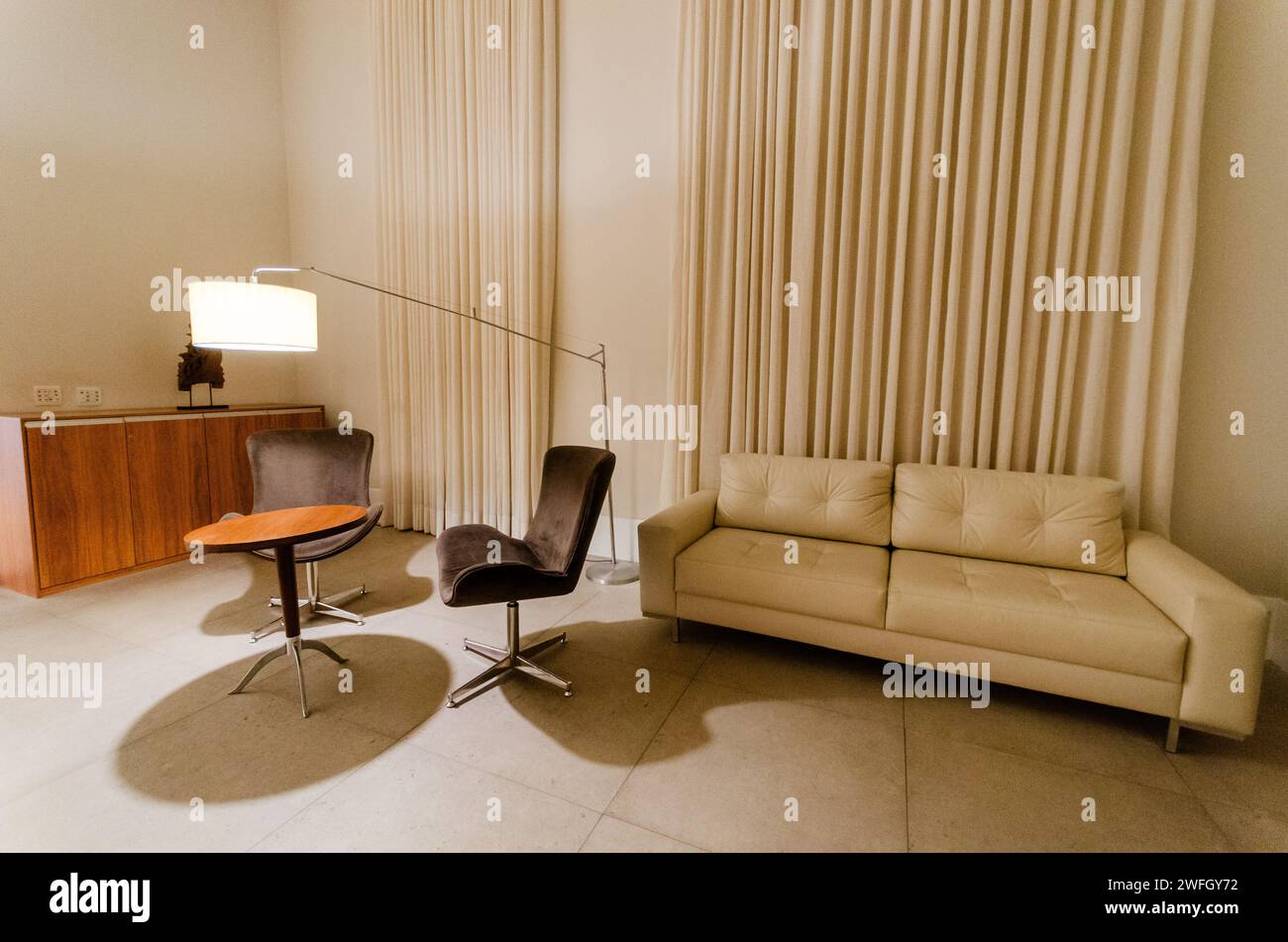 Una sedia e un divano sono situati nell'angolo di una camera Foto Stock