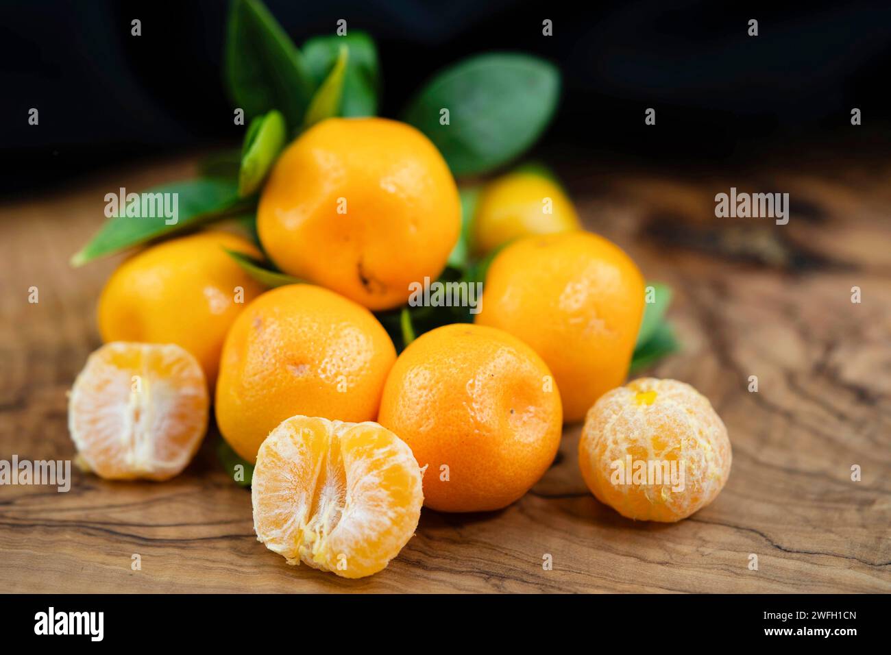 Calamondin, Calomondin, Camalmansi (Citrus madurensis, Citrofortunella microcarpa, Citrus fortunella, agrumi mitis), frutta in tavola, parzialmente sbucciata Foto Stock