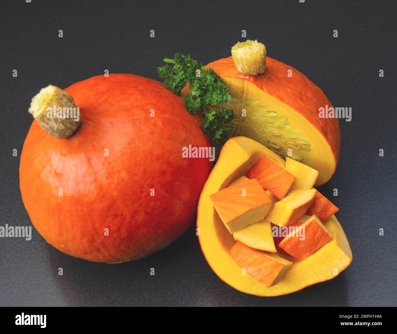 Squash kuri rosso, squash Hokkaido, Hokkaido, squash kuri rosso (Cucurbita maxima 'Hokkaido', Cucurbita maxima Hokkaido), tagliati su sfondo nero Foto Stock