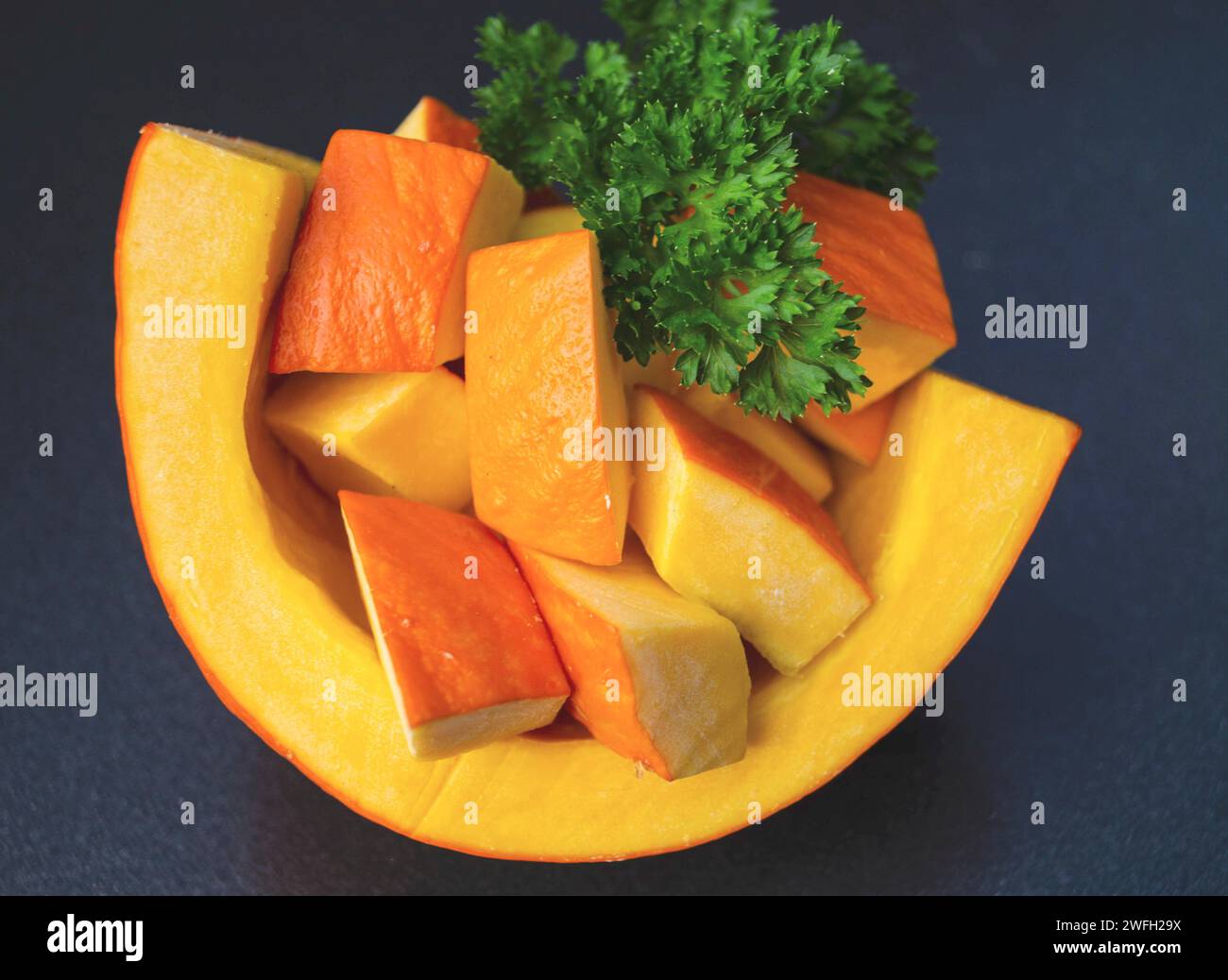 Squash kuri rosso, squash Hokkaido, Hokkaido, squash kuri rosso (Cucurbita maxima 'Hokkaido', Cucurbita maxima Hokkaido), tagliati su sfondo nero Foto Stock
