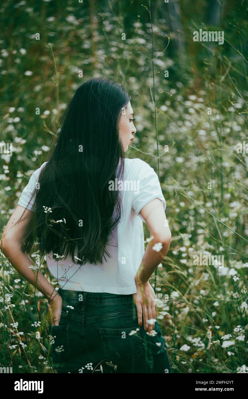 Triste giovane donna in piedi sul campo Foto Stock