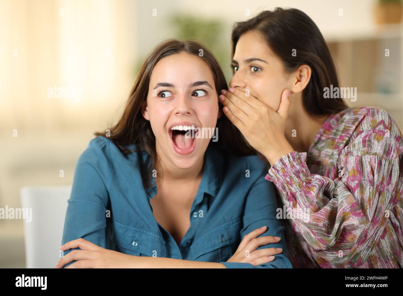 Donna che racconta un segreto incredibile ad un amico a casa Foto Stock