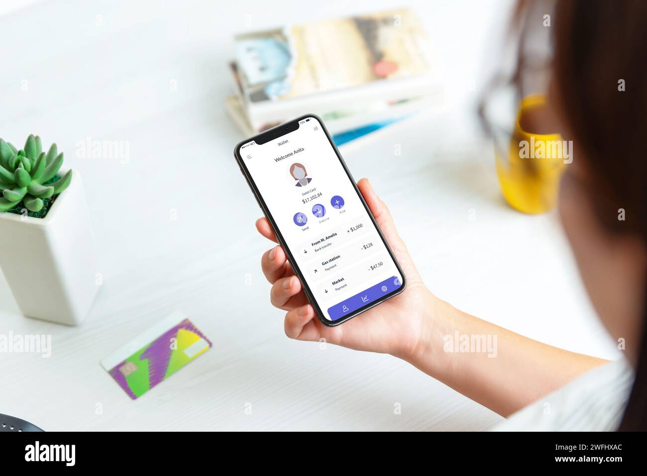 Woman aggiunge carta di credito e account su un'app di servizi fintech, visualizzata su uno smartphone moderno. Con l'account e un elenco di transazioni per marittimi Foto Stock