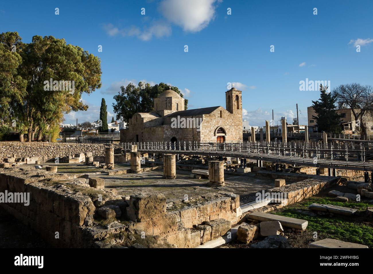 Paphos, Cipro - 23 dicembre 2023: La storica chiesa cattolica di Agia Kyriaki dal 1500 d.C. e le rovine della basilica di Chrysopolitissa dal IV secolo d.C. Foto Stock