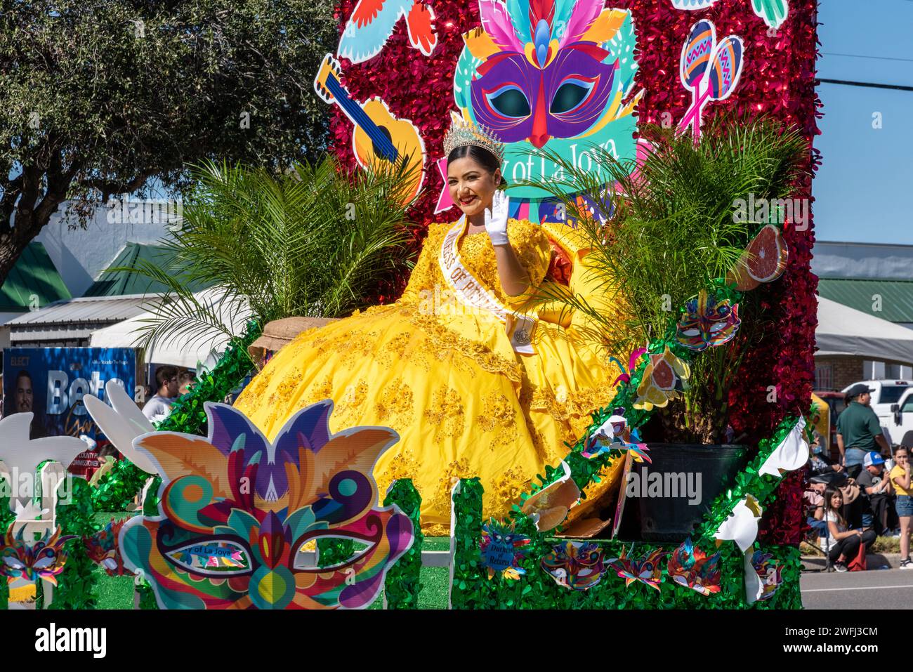 Giovane donna in abito giallo su un galleggiante in parata che salta alla 92a Parata annuale delle arance del Texas Citrus Fiesta, Mission, Texas, USA. Foto Stock