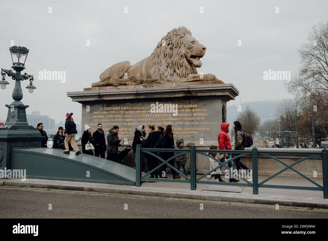 Gruppo di individui riuniti vicino a un'enorme scultura stradale Foto Stock
