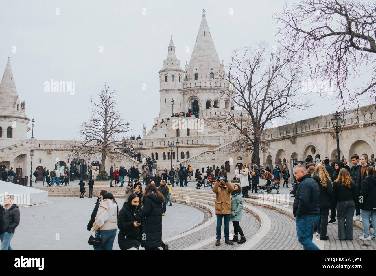 Gruppo di persone sulle scale e in un cortile con più persone Foto Stock