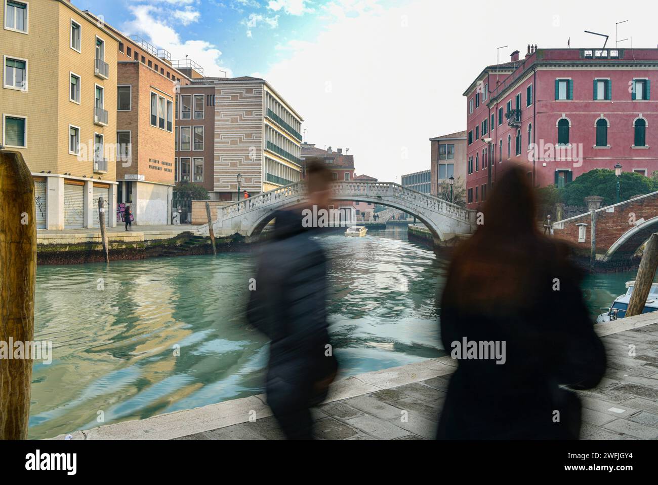 Turisti sfocati passeggiando lungo i numerosi ponti e canali di Venezia. Foto Stock