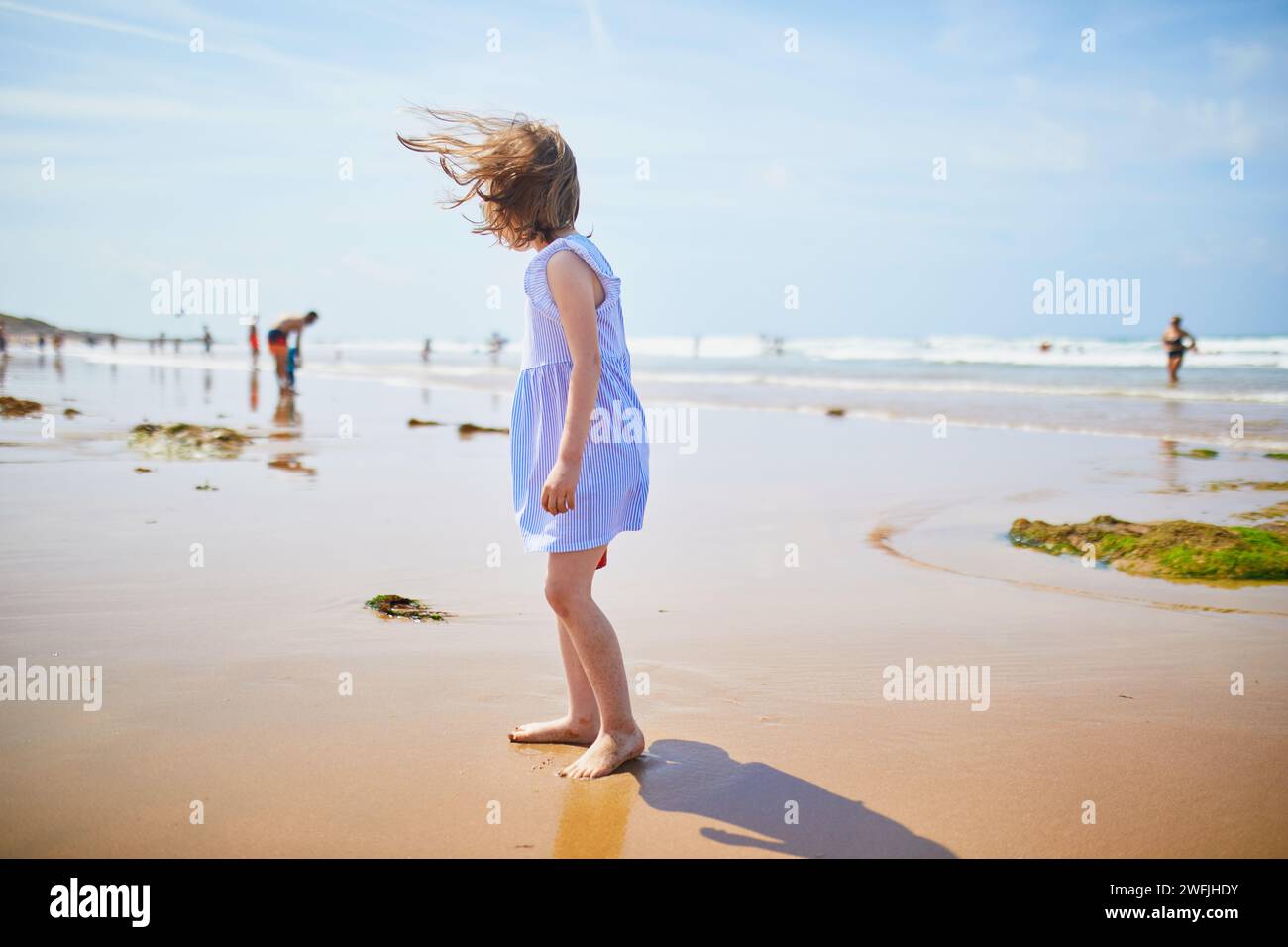Adorabile bambina in età prescolare che gioca sulla spiaggia di sabbia della costa atlantica della Bretagna, in Francia. Bambini piccoli che si divertono in vacanza al mare o all'oceano. Travelli Foto Stock