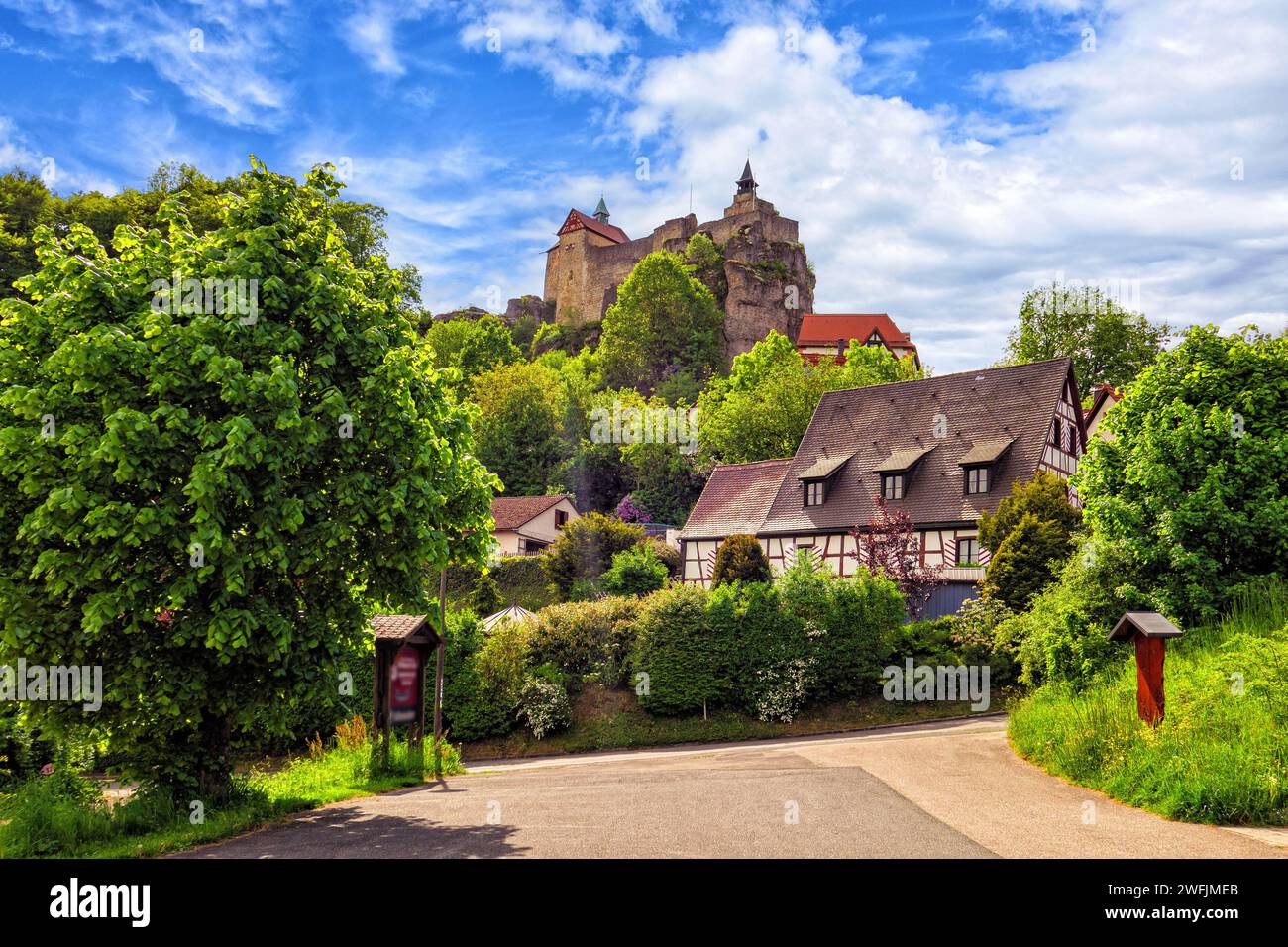 Vista del castello di Hohenstein con le vecchie case in legno a graticcio nella media Franconia vicino a Norimberga, Baviera, Germania, di fronte a un cielo bianco-blu Foto Stock