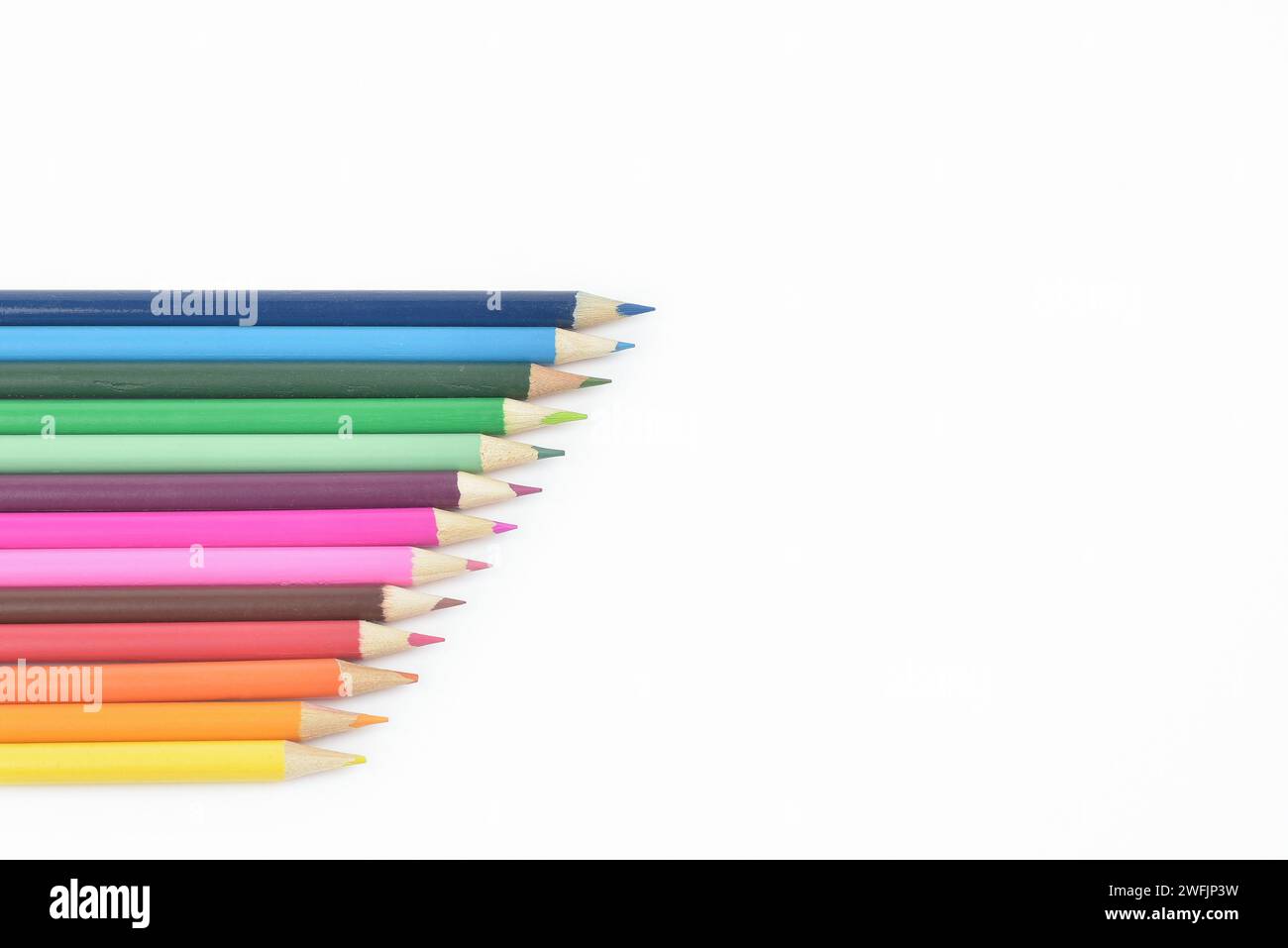 Set di matite colorate in legno senza cuciture posizionate in una fila isolata su sfondo chiaro Foto Stock