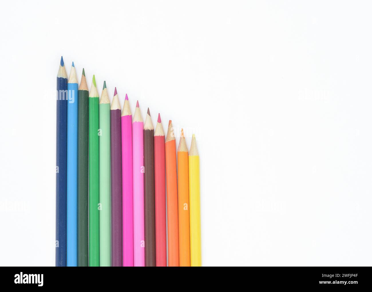 Set di matite colorate in legno senza cuciture posizionate in una fila isolata su sfondo chiaro Foto Stock