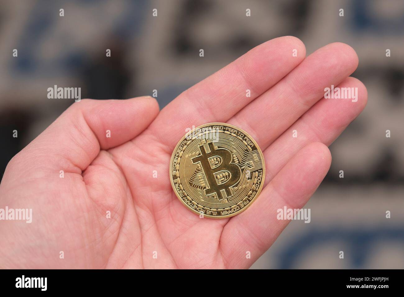 Moneta Bitcoin in mano a un uomo Foto Stock