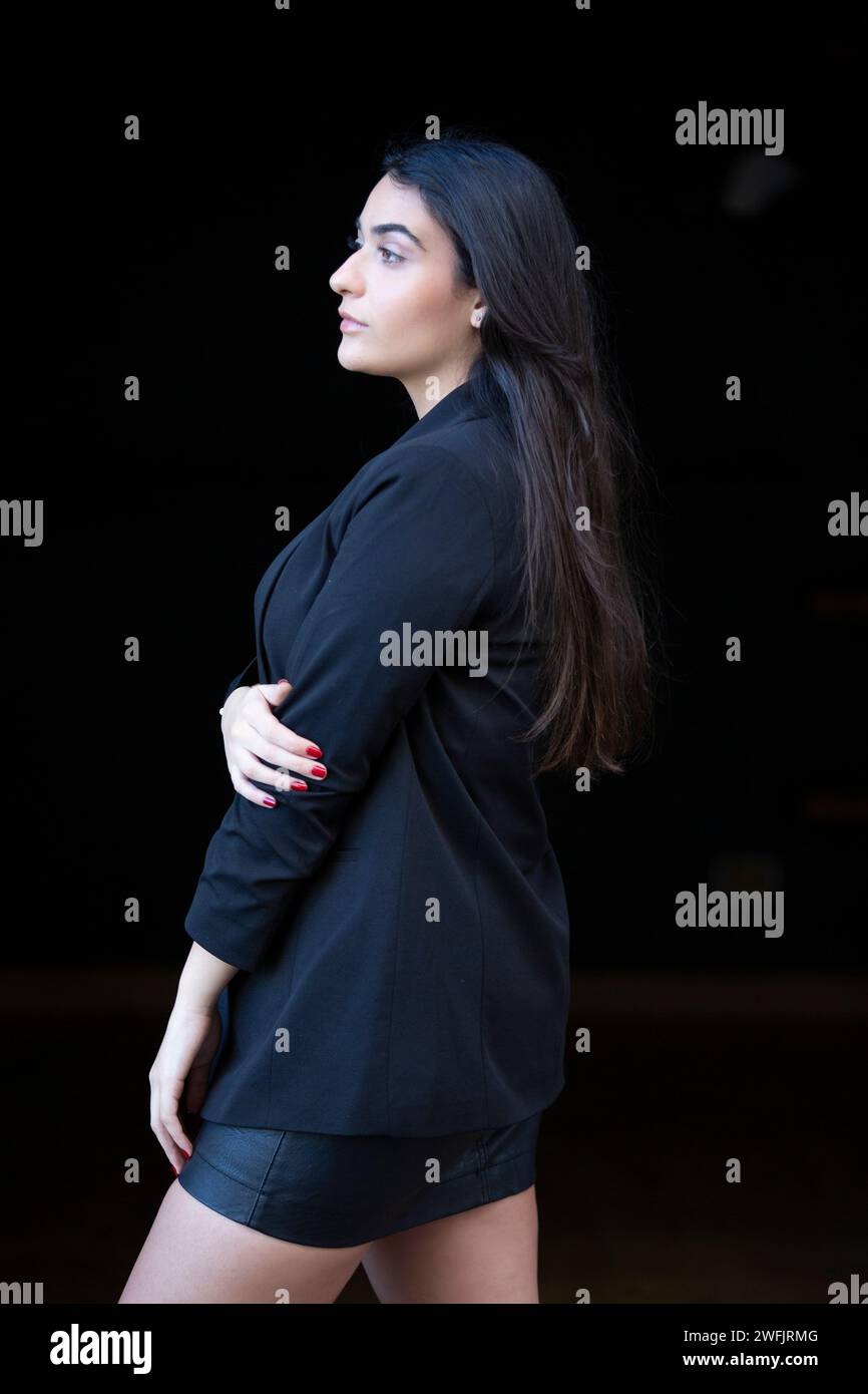 Vista laterale della giovane donna che guarda lontano Foto Stock