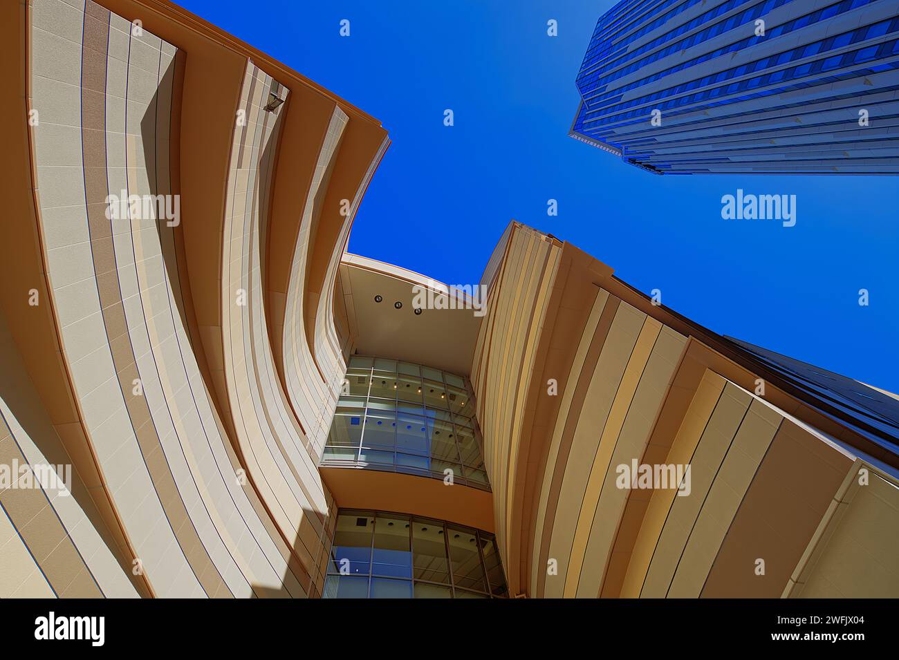 Vista da sotto gli edifici moderni con una facciata a gradini, luci e ombre Foto Stock