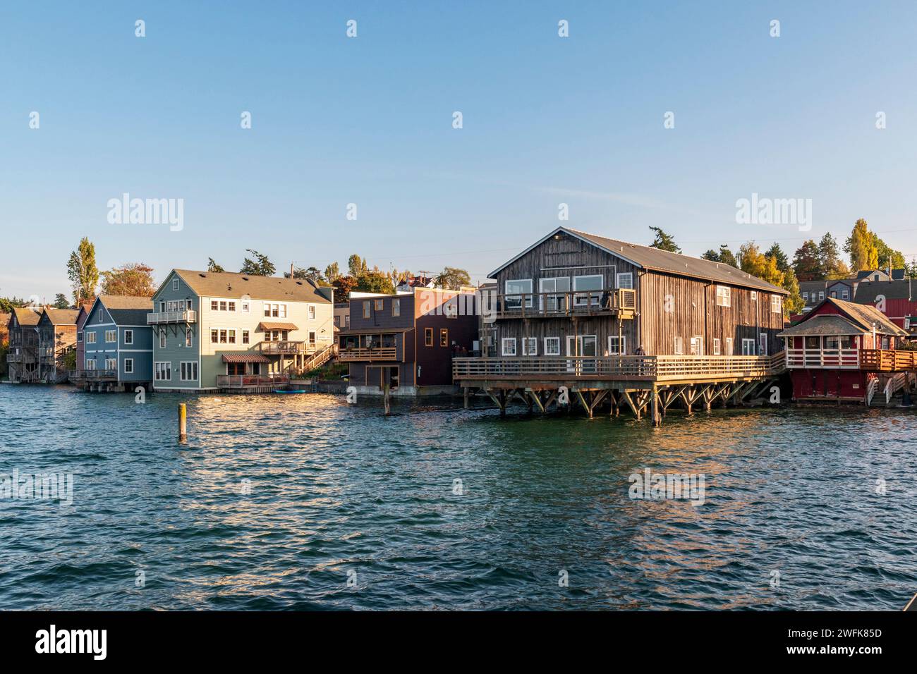 Edifici storici in legno costruiti su pilastri si innalzano nell'acqua a Penn Cove a Coupeville, Whidbey Island, Washington. Foto Stock