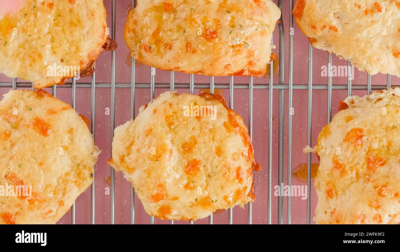 Biscotti al formaggio appena sfornati in primo piano su una griglia di raffreddamento, su una base piatta Foto Stock