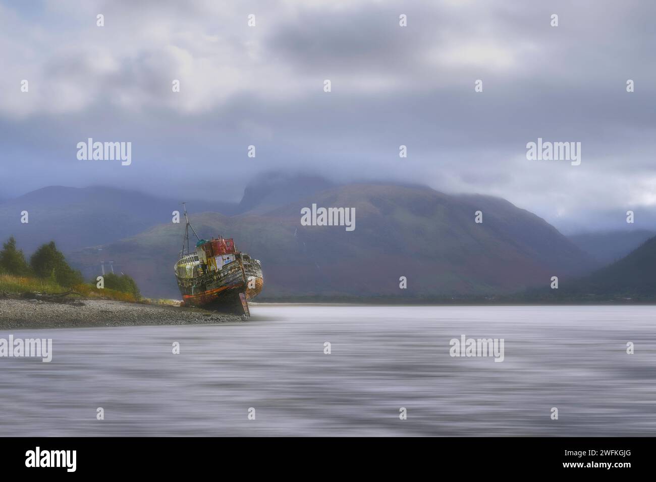 La vecchia barca di Caol o Corpach Wreck si trova sulla riva dove Loch Linne e Loch EIL si incontrano sulla costa occidentale scozzese. Guarda fino a Ben Nevis. Foto Stock