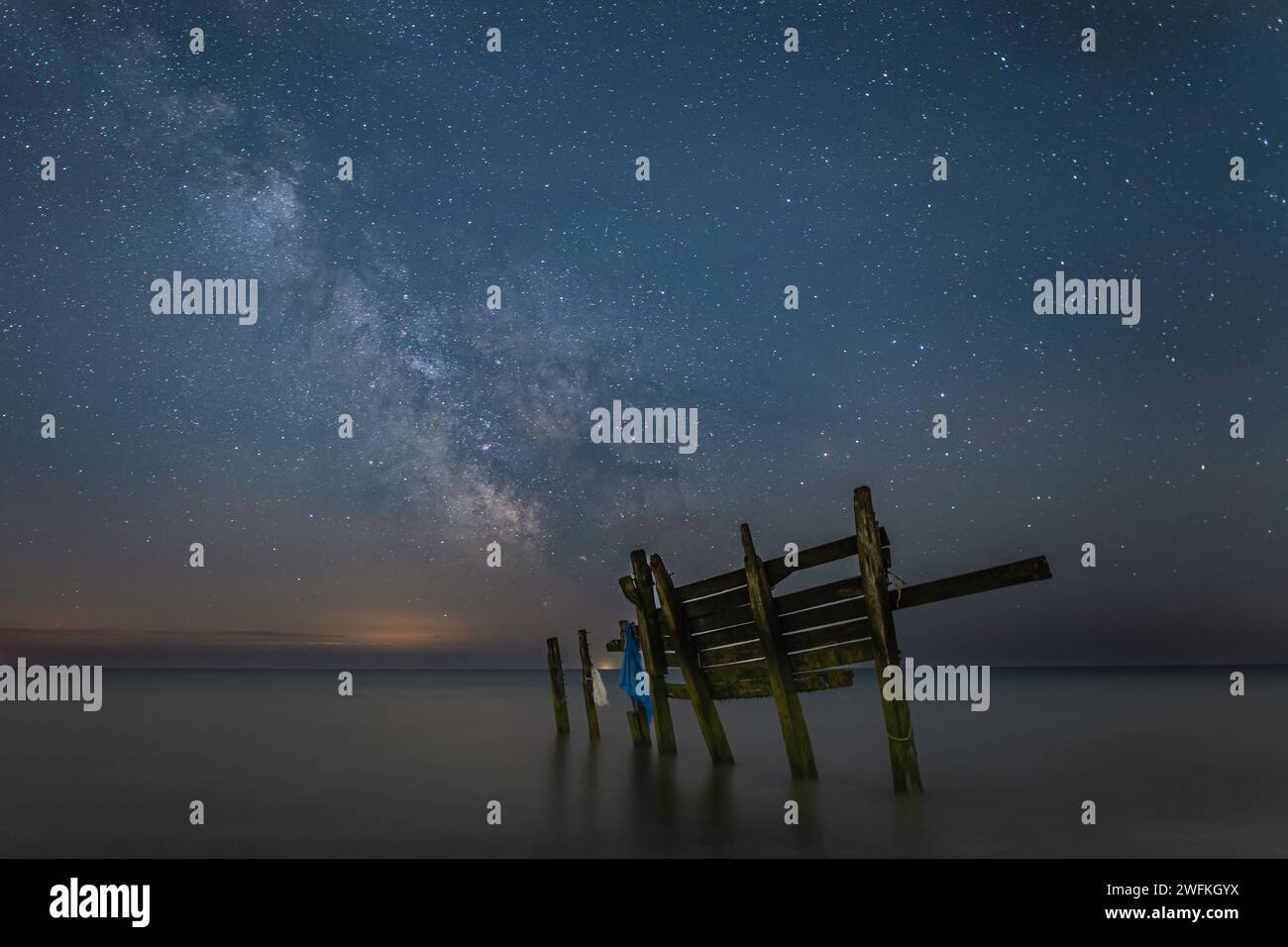 Immagine della via Lattea scattata dalla spiaggia di Climping con parti di una vecchia difesa del mare in primo piano. Foto Stock