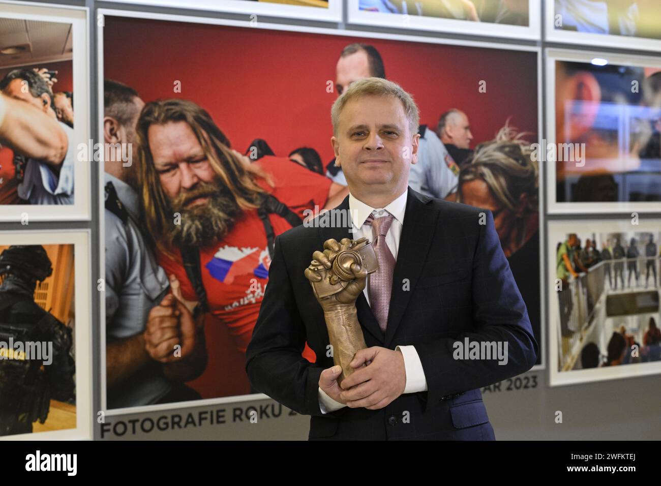 Praga, Repubblica Ceca. 31 gennaio 2024. La cerimonia di premiazione del 29° concorso fotografico della stampa ceca si è tenuta a Praga, Repubblica Ceca, il 31 gennaio 2024. Roman Vondrous, fotografo della Czech News Agency (CTK), che ha vinto il premio principale per la fotografia dell'anno 2023, si pone con il premio davanti alla sua fotografia. Crediti: Katerina Sulova/CTK Photo/Alamy Live News Foto Stock