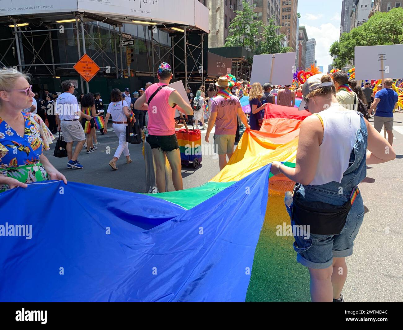 Alla parata del New York Gay Pride, i partecipanti svelano la bandiera arcobaleno, mostrando il loro sostegno alla comunità LBGT Foto Stock