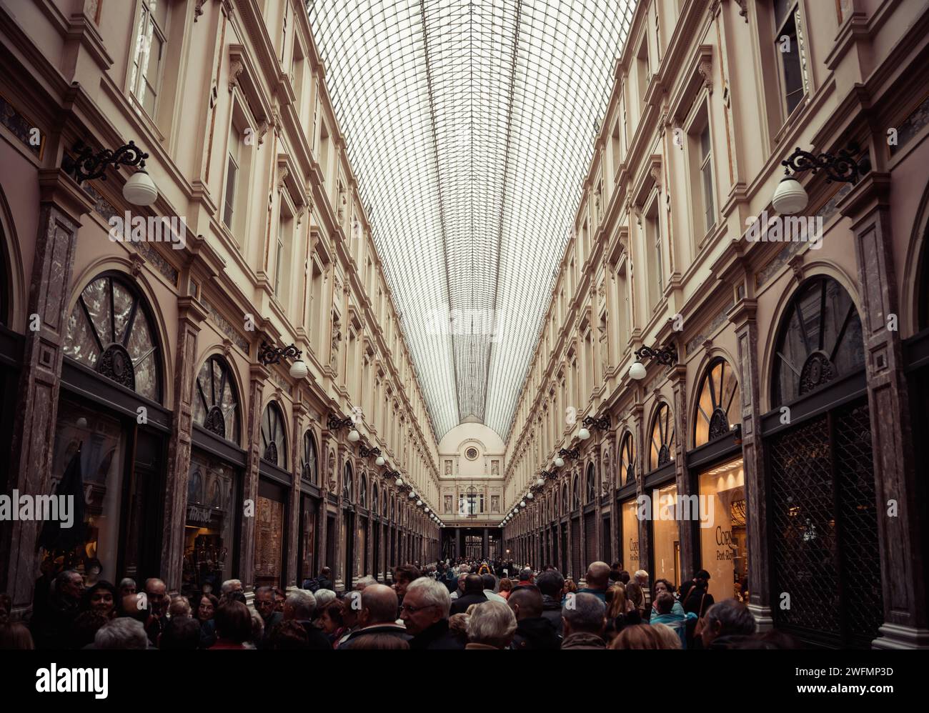 Royal Saint-Hubert Galleries a Bruxelles. Sminuendo la prospettiva di una galleria di negozi smaltata con la folla di turisti che camminano lungo la strada Foto Stock