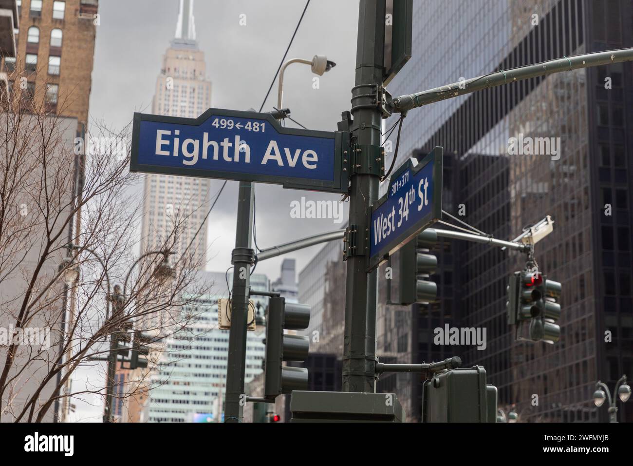 Cartello per 8th Avenue e West 34th Street a New York City con l'Empire State Building sullo sfondo Foto Stock