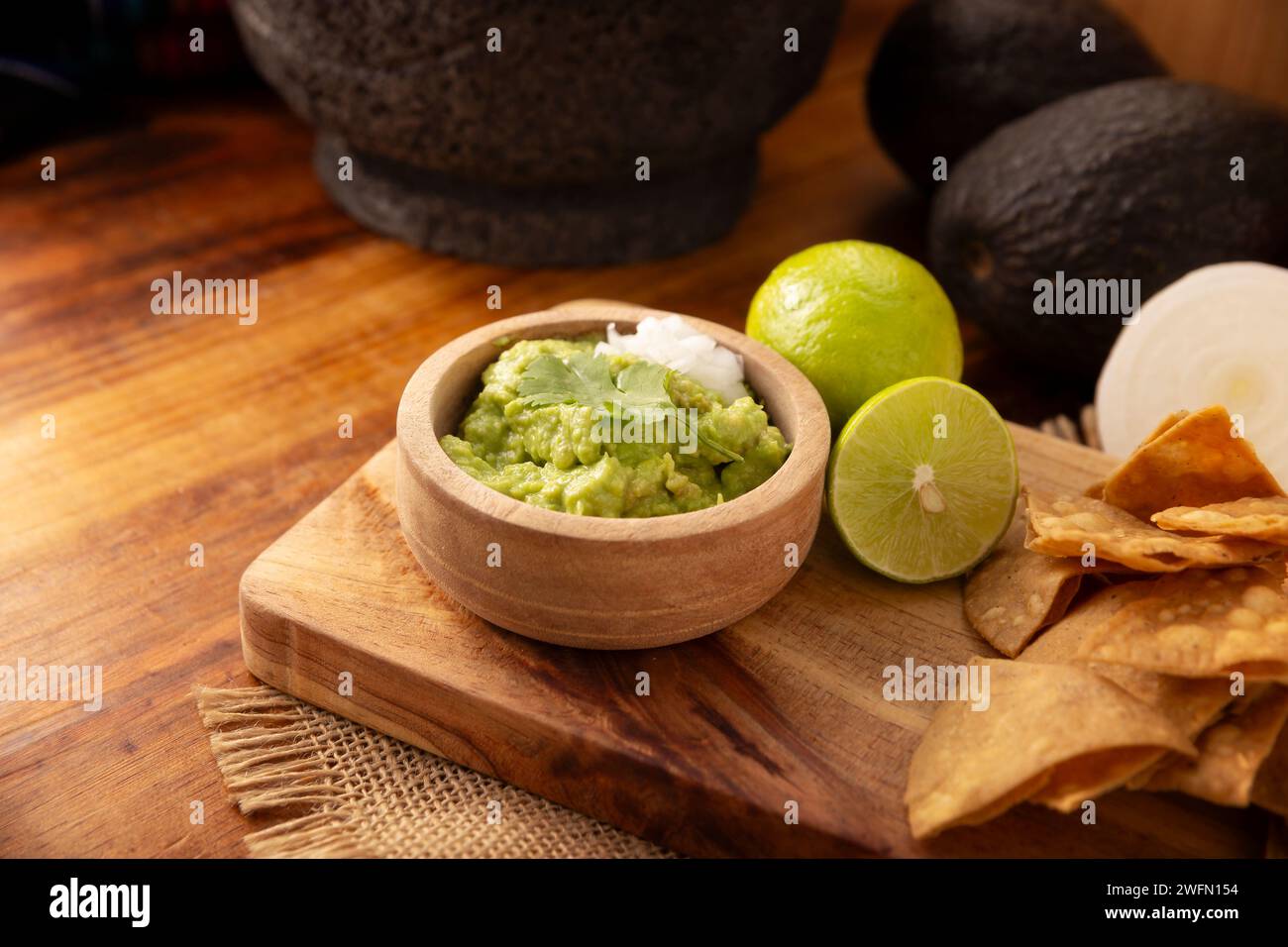 Guacamole. La salsa all'avocado, uno dei suoi molti modi di consumarla, è sparsa su patatine di tortilla chiamate anche Nachos. Ricetta messicana con salsa casereccia semplice Foto Stock