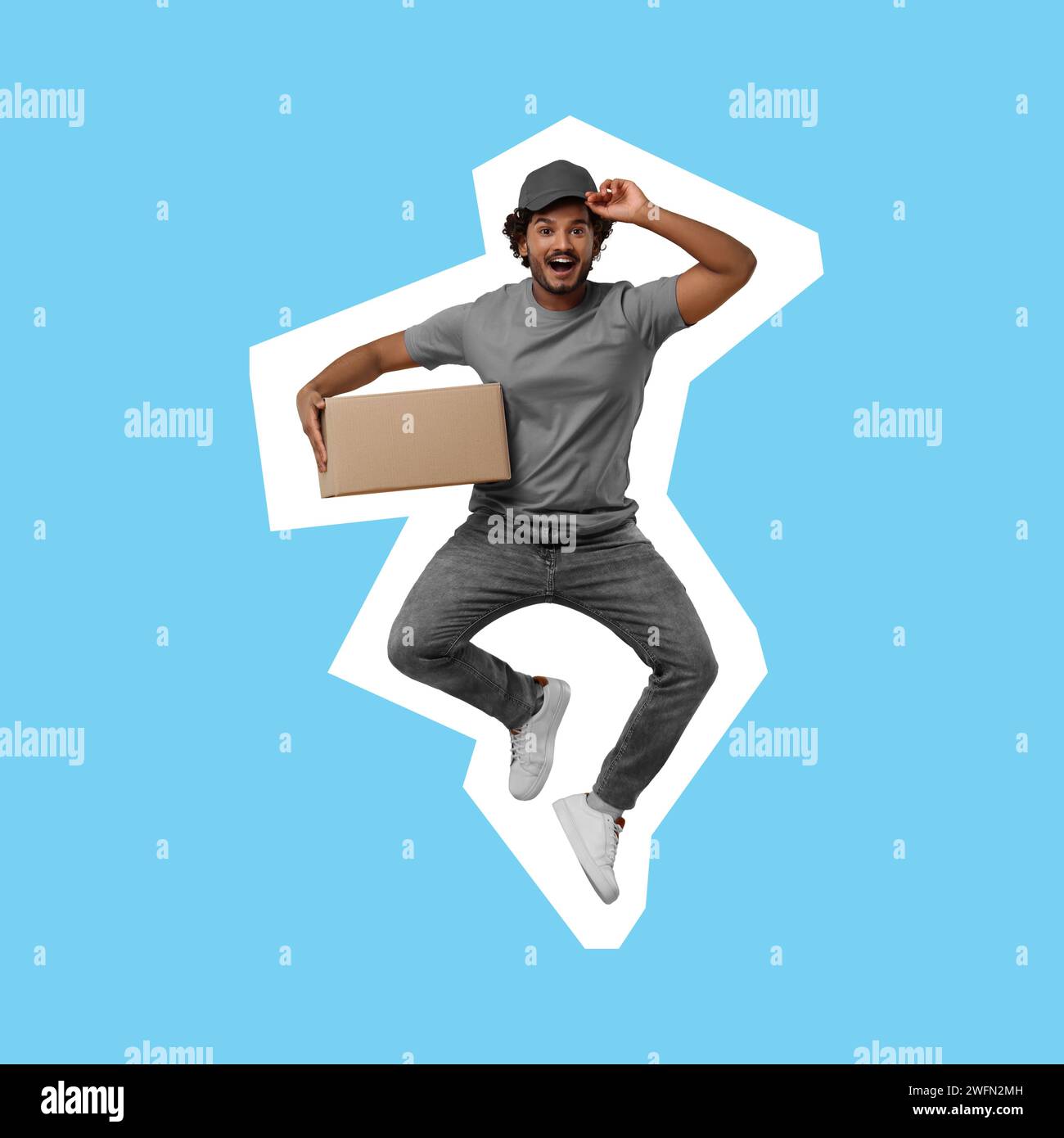 Corriere sorpreso con pacco che salta su sfondo azzurro Foto Stock