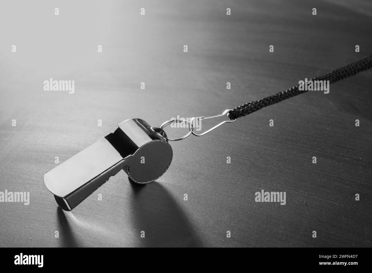 Attrezzatura per arbitri. Fischio metallico su tavola grigia, primo piano e spazio per il testo Foto Stock