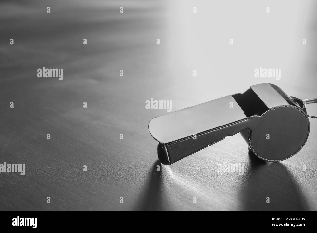 Attrezzatura per arbitri. Fischio metallico su tavola grigia, primo piano e spazio per il testo Foto Stock