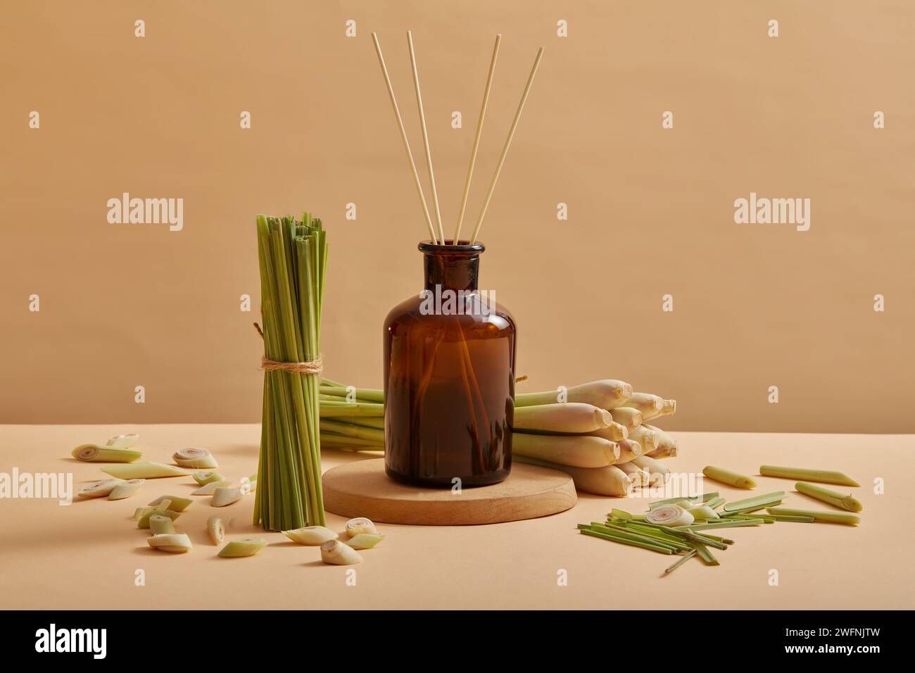 Un vaso di vetro contenente olio essenziale estratto dalla citronella (Cymbopogon citratus) con diffusori di canna, da usare per profumare la stanza e aiutare le persone Foto Stock