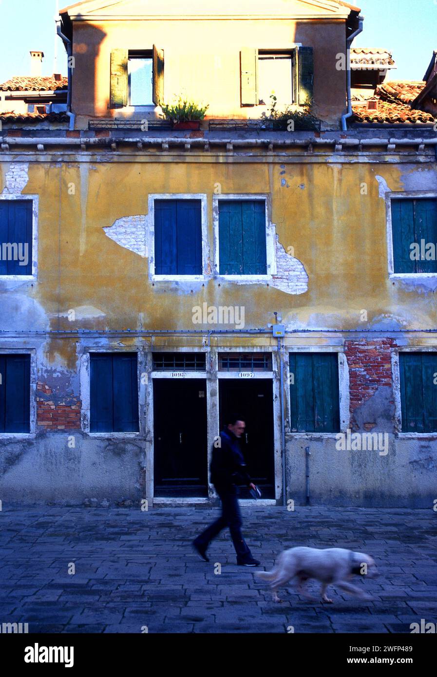 Uomo che cammina, e architettura residenziale, Venezia, Italia Foto Stock