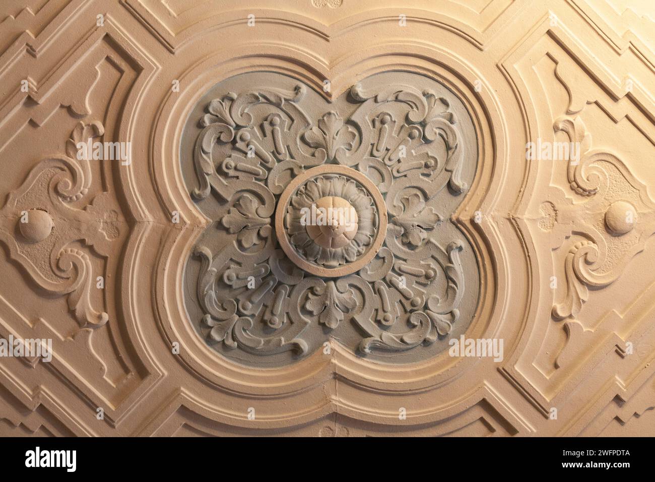 Rosetta in gesso con motivo geometrico sul soffitto di un antico maniero. Foto Stock