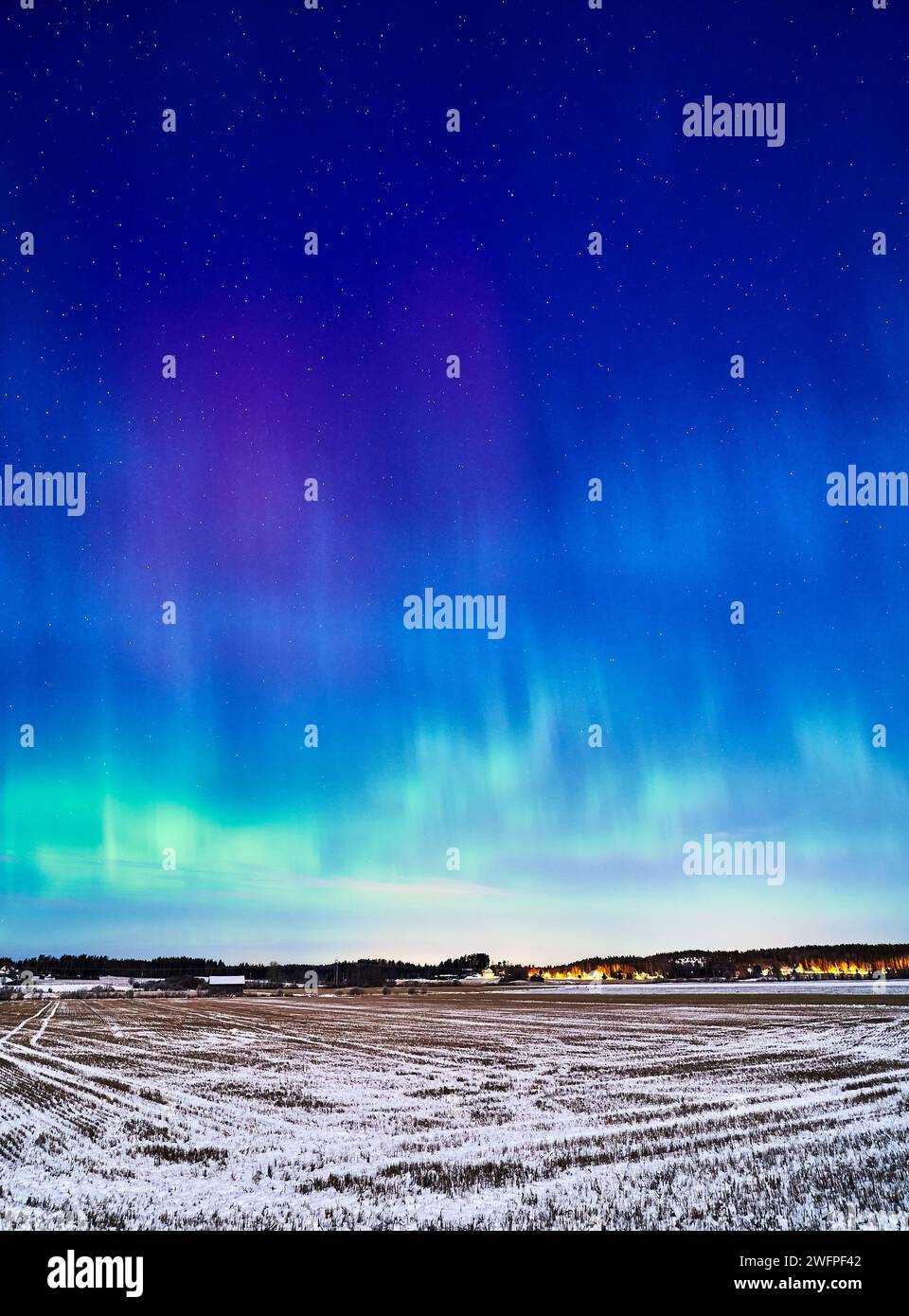 Una splendida esposizione dell'aurora boreale che illumina il cielo e un campo pittoresco Foto Stock